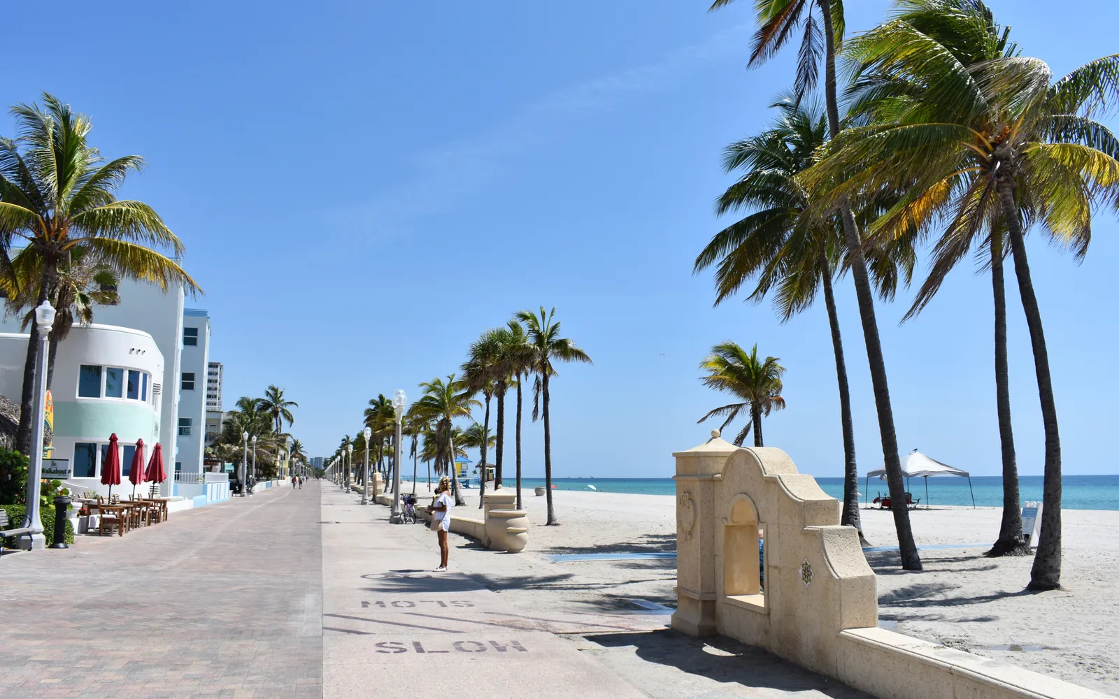The Hollywood Beach Broadwalk lined with palm trees next to the ocean in Hollywood, Florida